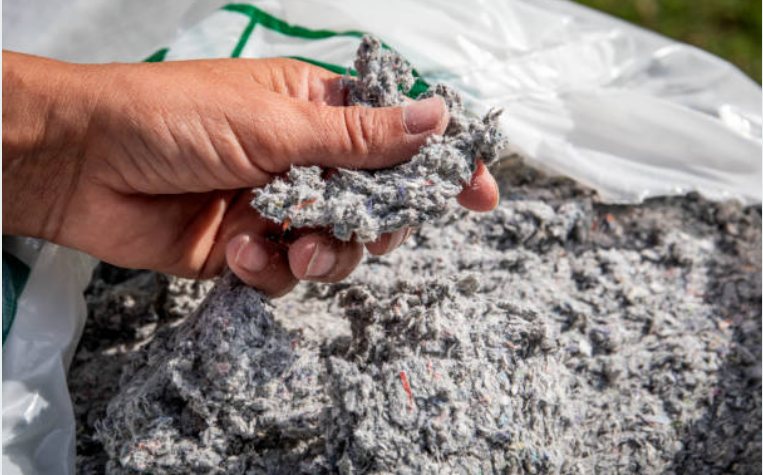 A handful of dense-pack cellulose insulation, the material used inside wall cavities